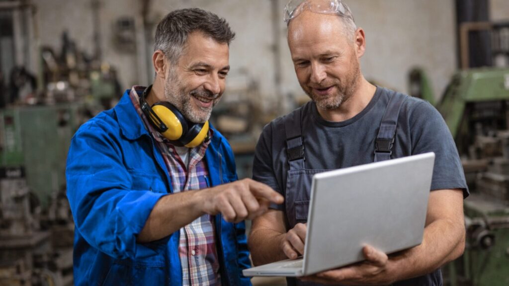 Zwei Handwerker schauen sich die Betriebswebseite an